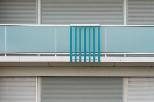 A contemporary balcony with blue accents and glass panels showcasing minimalism in architecture.