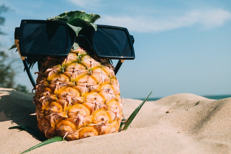 Pineapple Fruit With Sunglasses On Sand