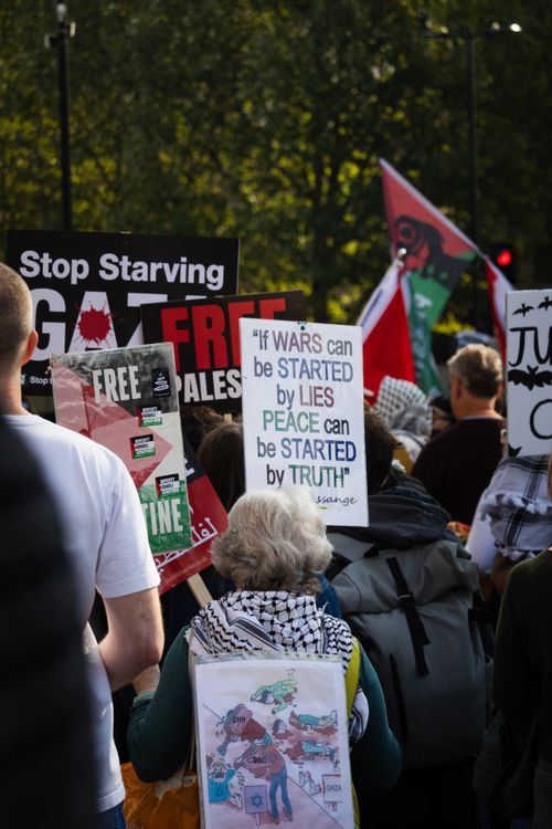 Free A protest in London with people holding signs advocating for peace and justice. Stock Photo