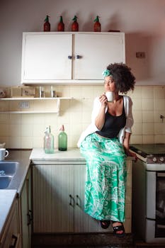 Woman sitting on kitchen counter enjoying a warm coffee moment.