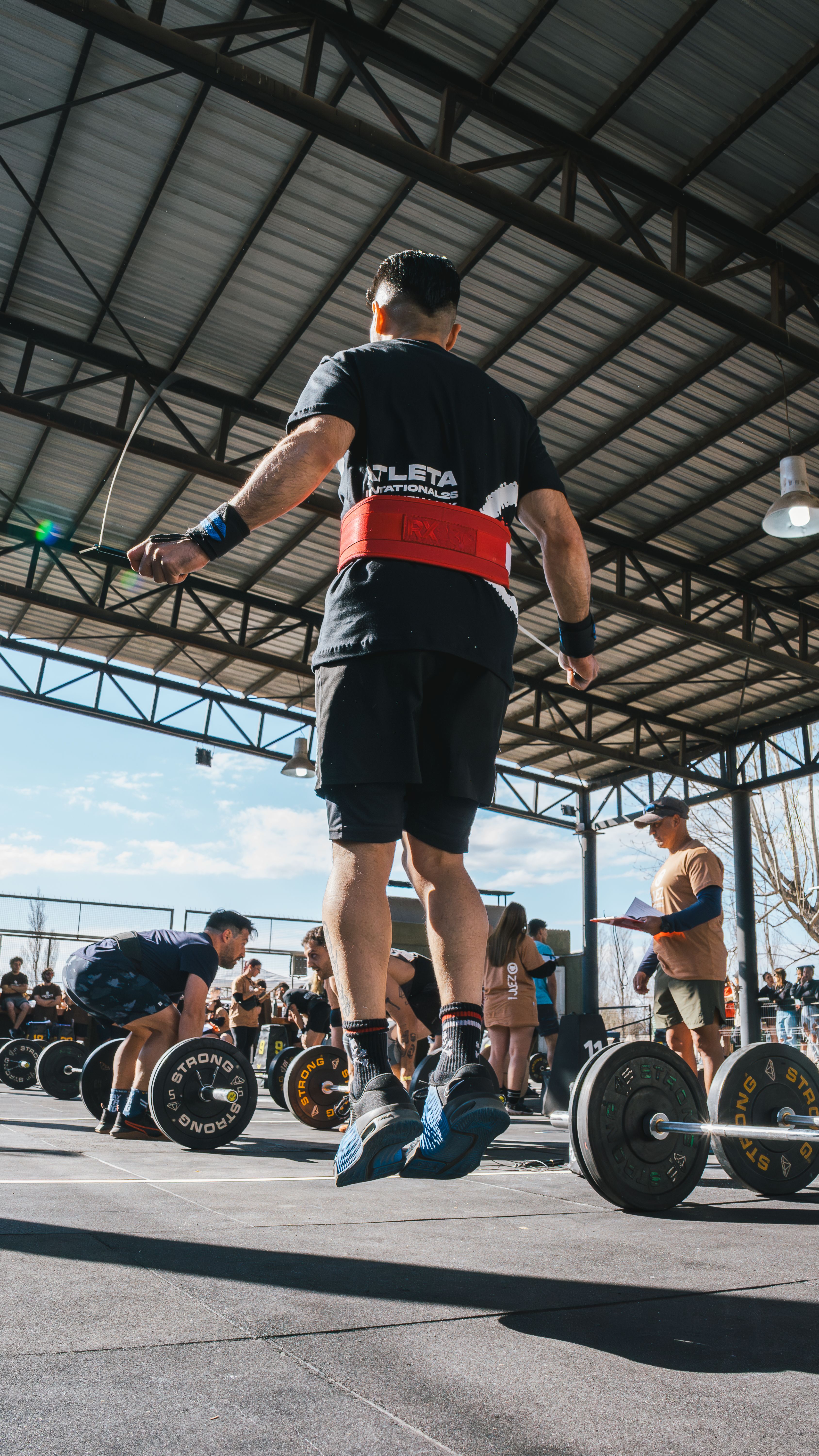 Athlete jumping rope during an intense CrossFit session outdoors in bright daylight.