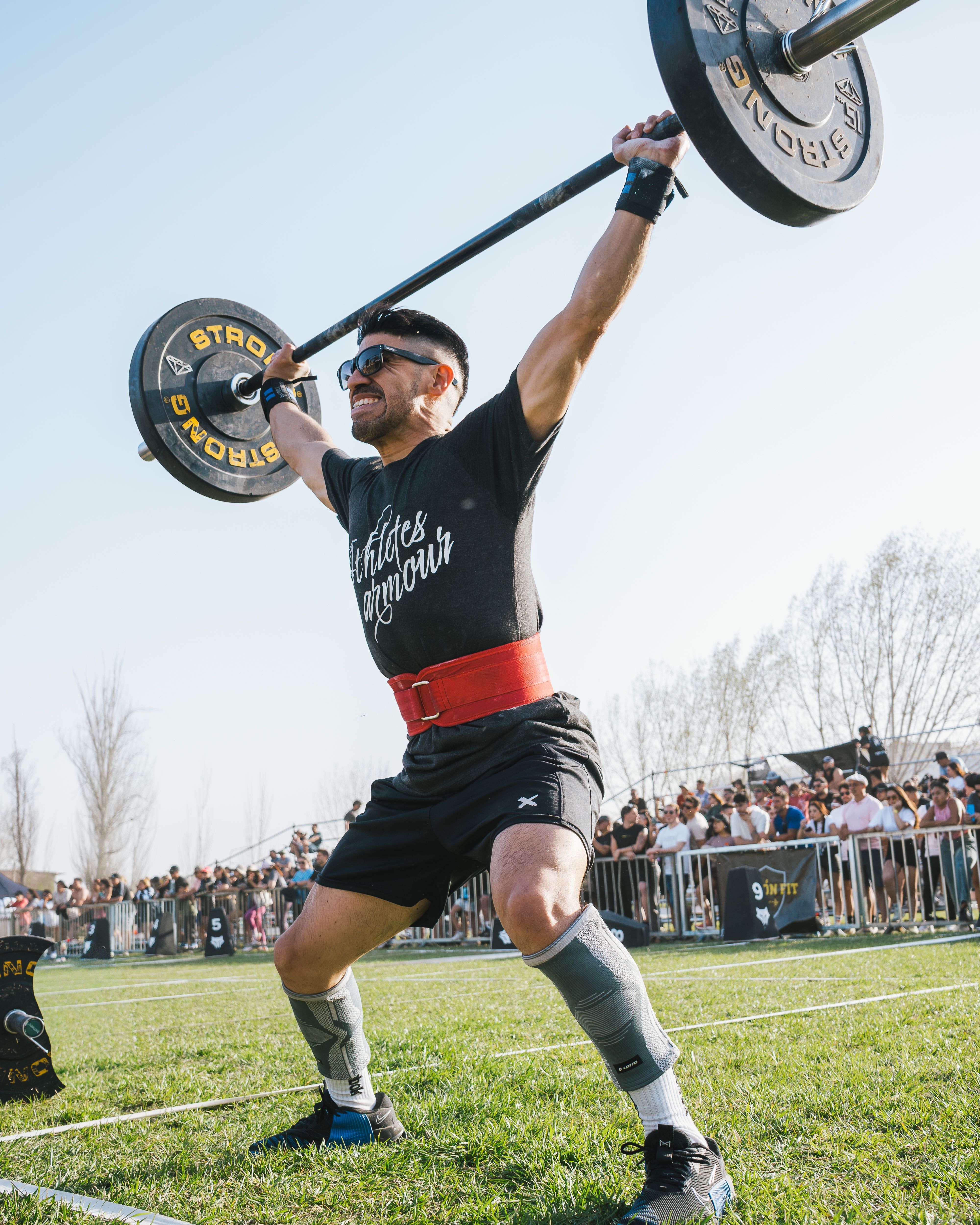 Portrait of coach Dario Venn, determined athlete lifting weights outdoors