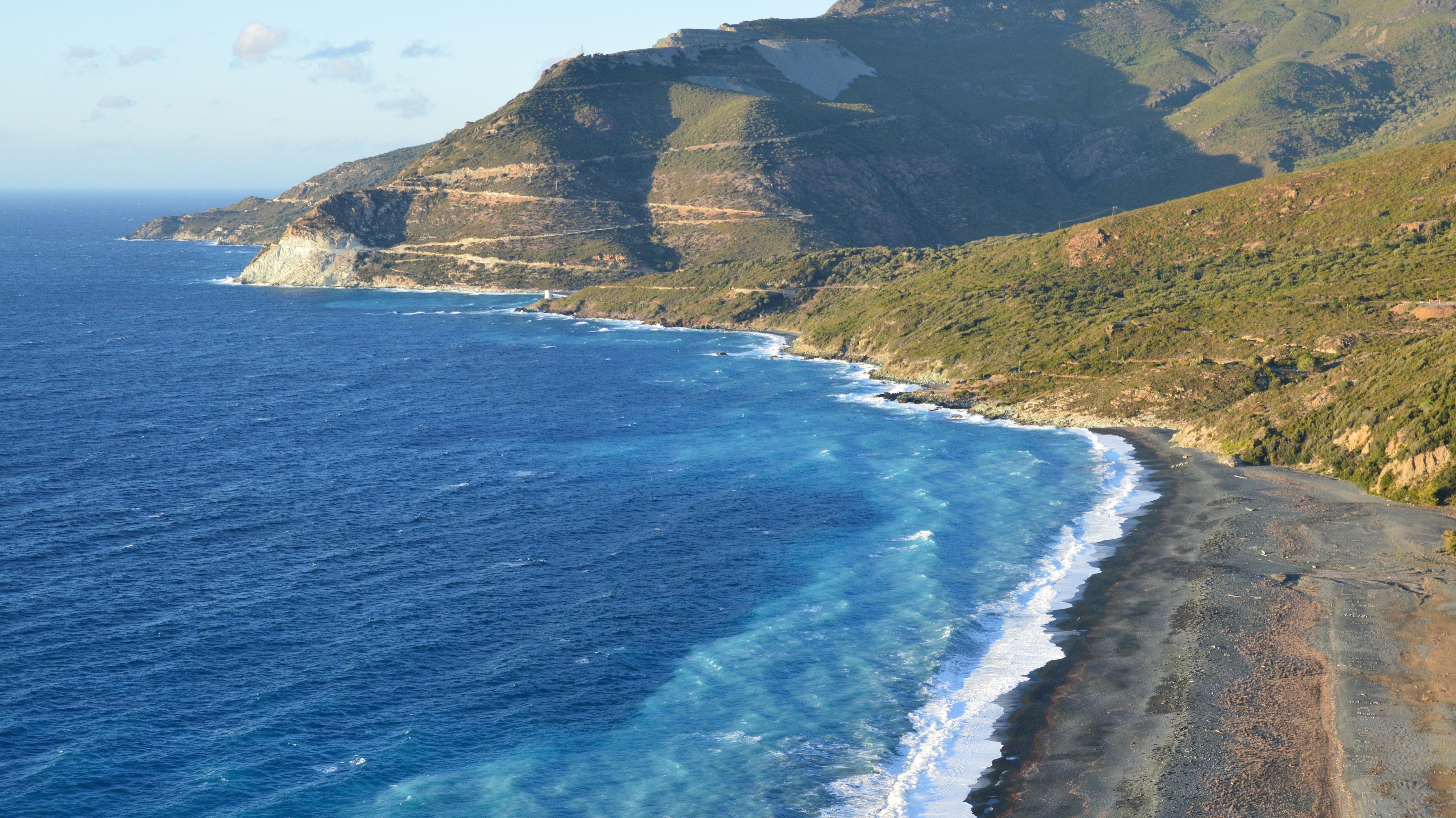 Breathtaking view of Nonza beach and coastal cliffs in Corsica, France.