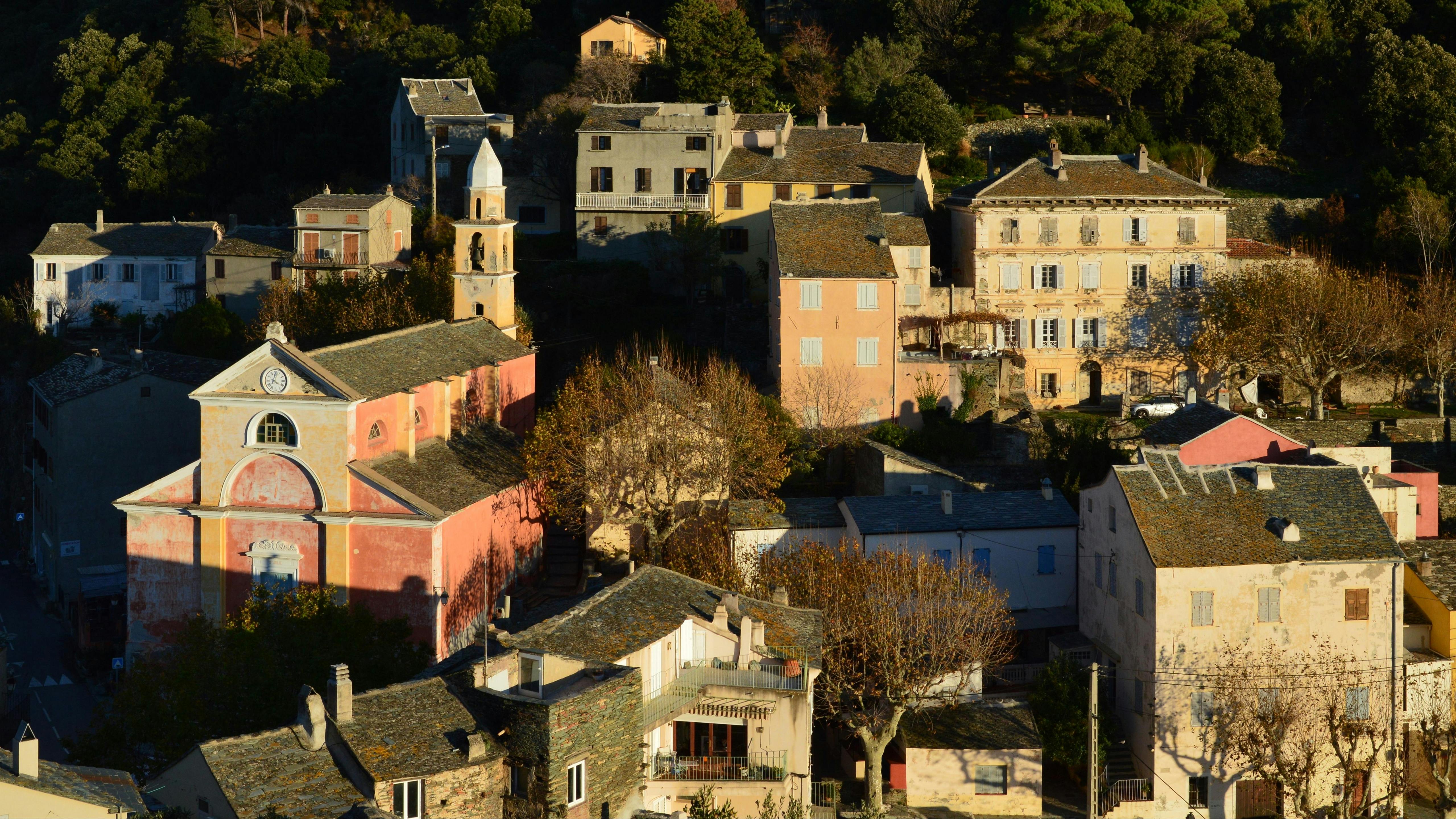 Picturesque view of a traditional Corse village at sunset, showcasing historic architecture.