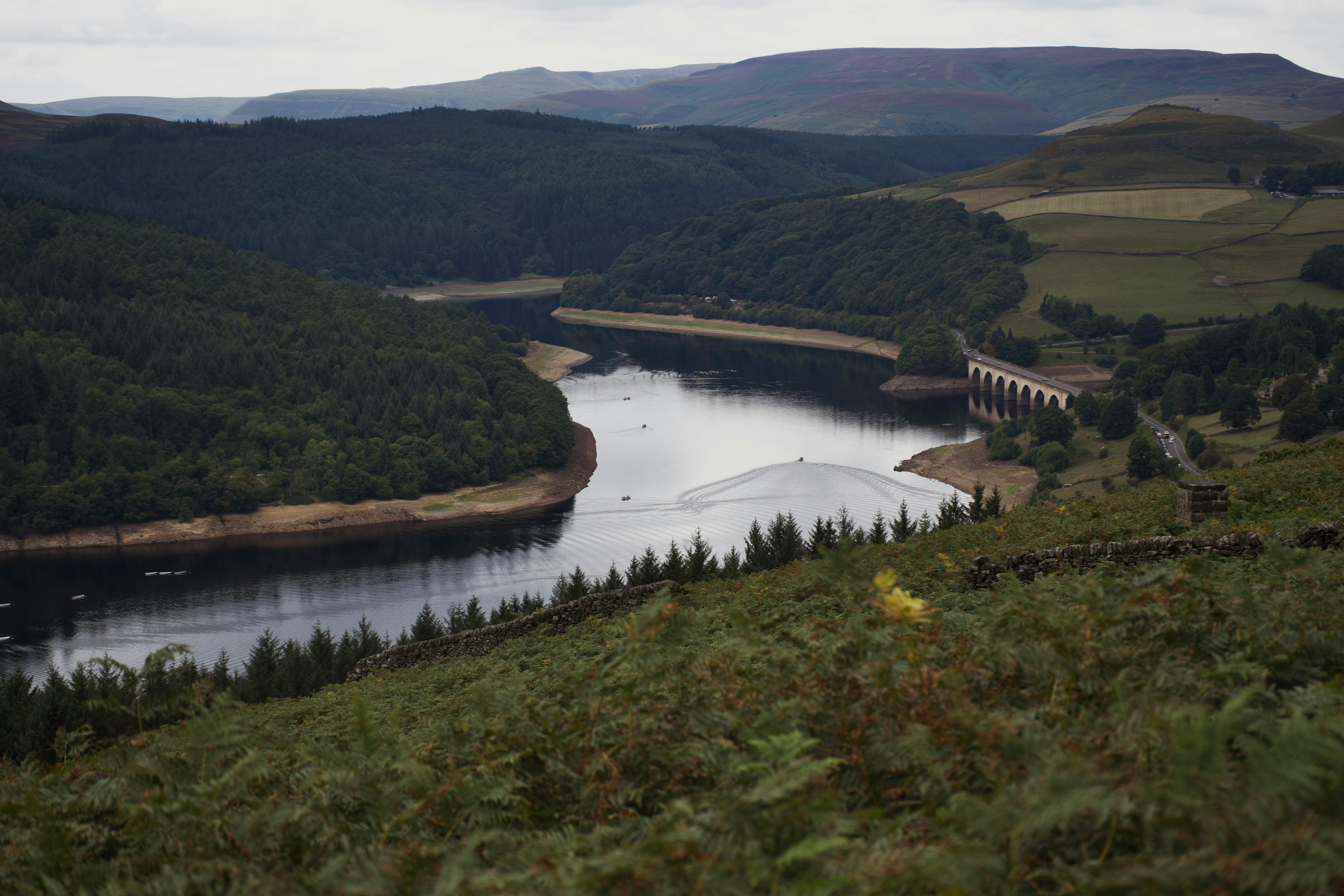 A picturesque view of Ladybower Reservoir surrounded by lush hills in the Peak District.