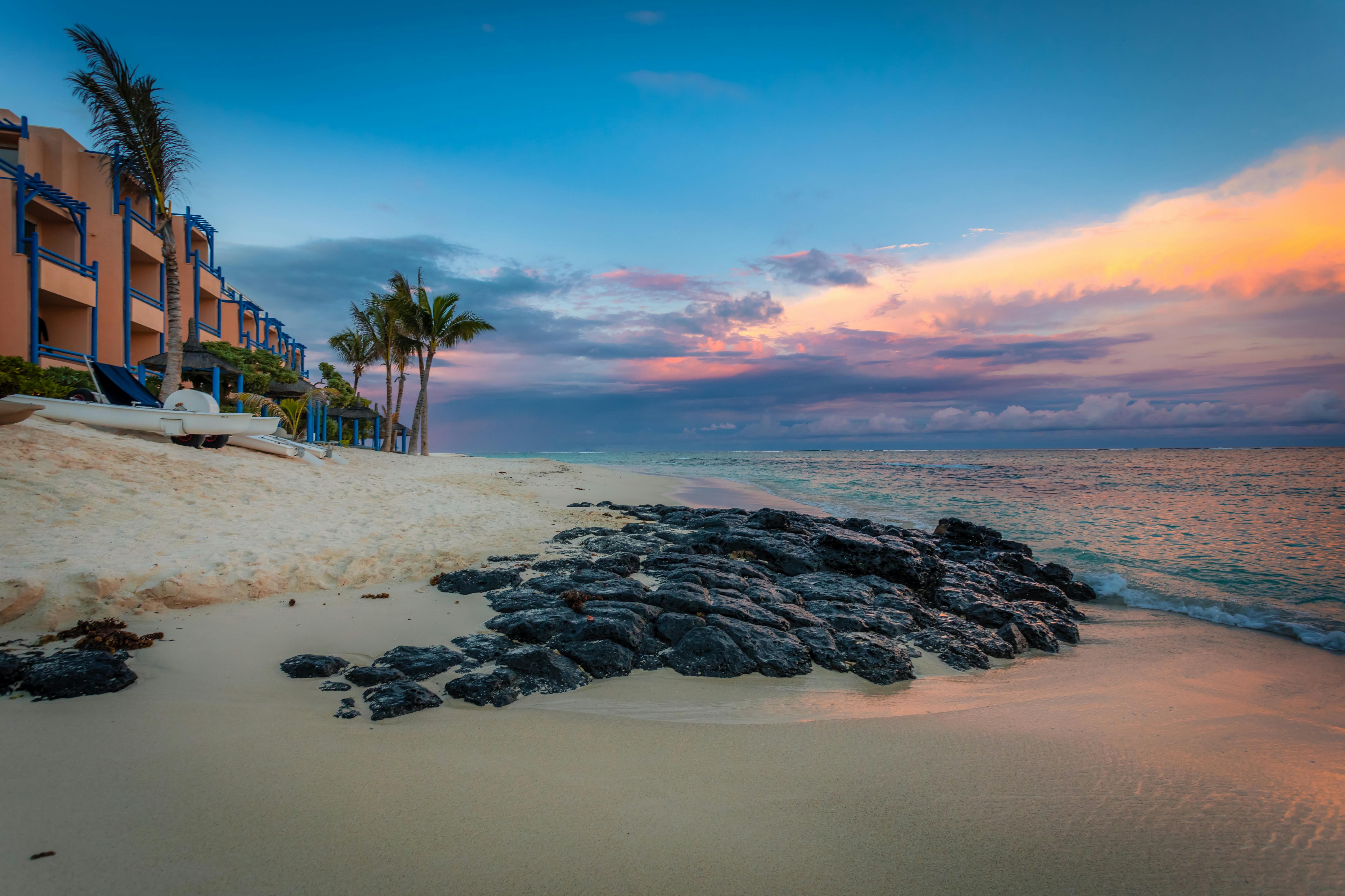 Breathtaking sunset view at a serene beach in Quatre Cocos, Mauritius, with golden sands and azure waves.