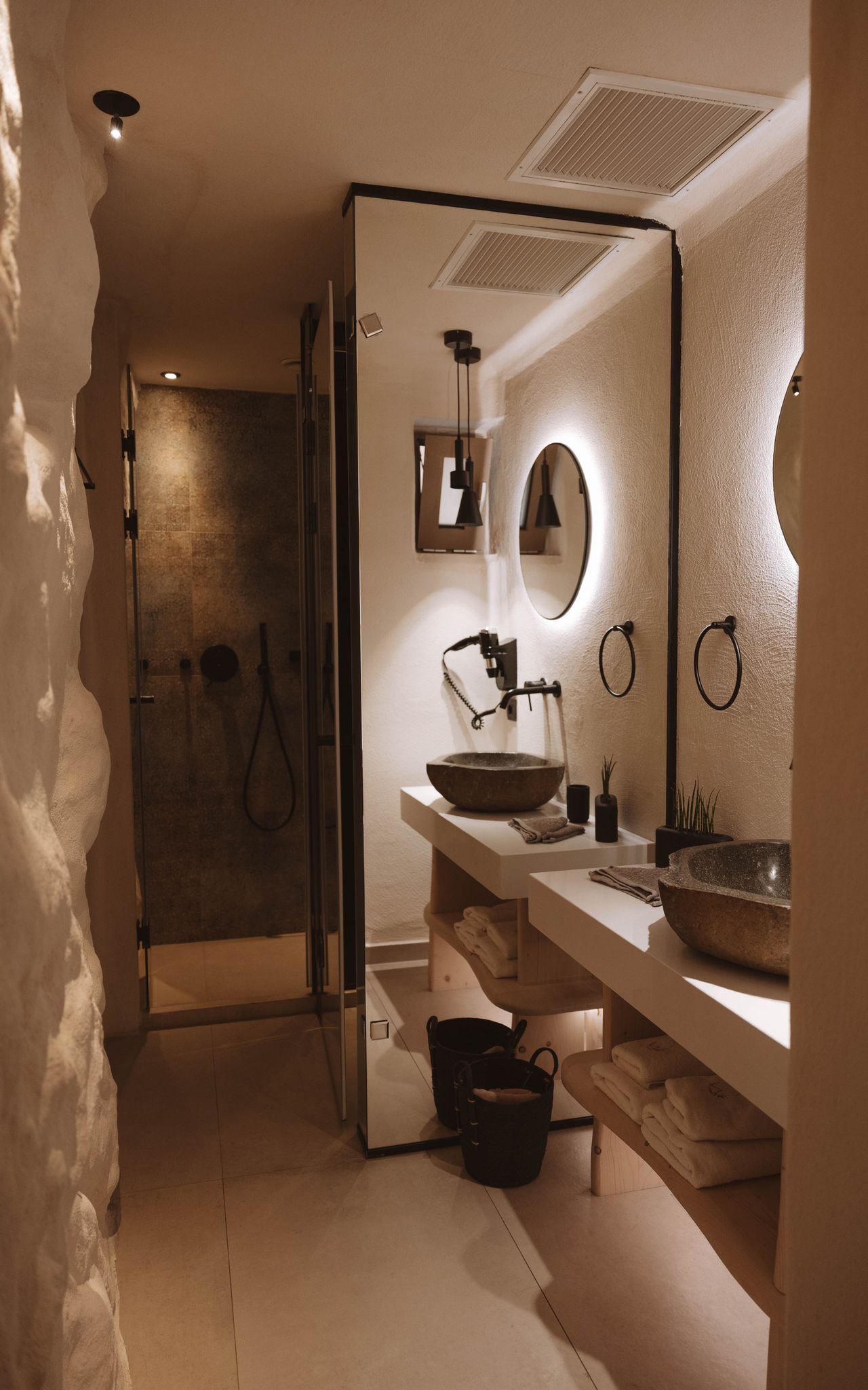 Elegant boutique hotel bathroom with stone vessel sinks and warm lighting