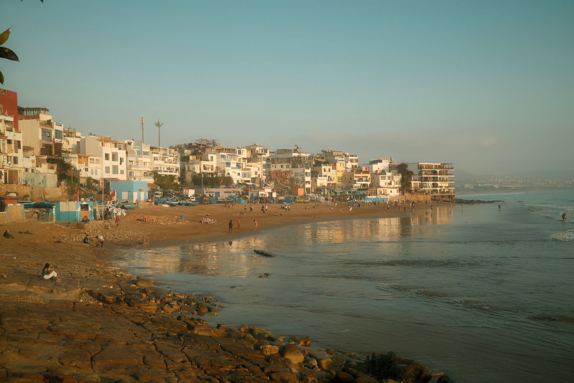 north coast beach event organizer — Beautiful coastal view of Rabat's beach with buildings, capturing a serene sunset atmosph