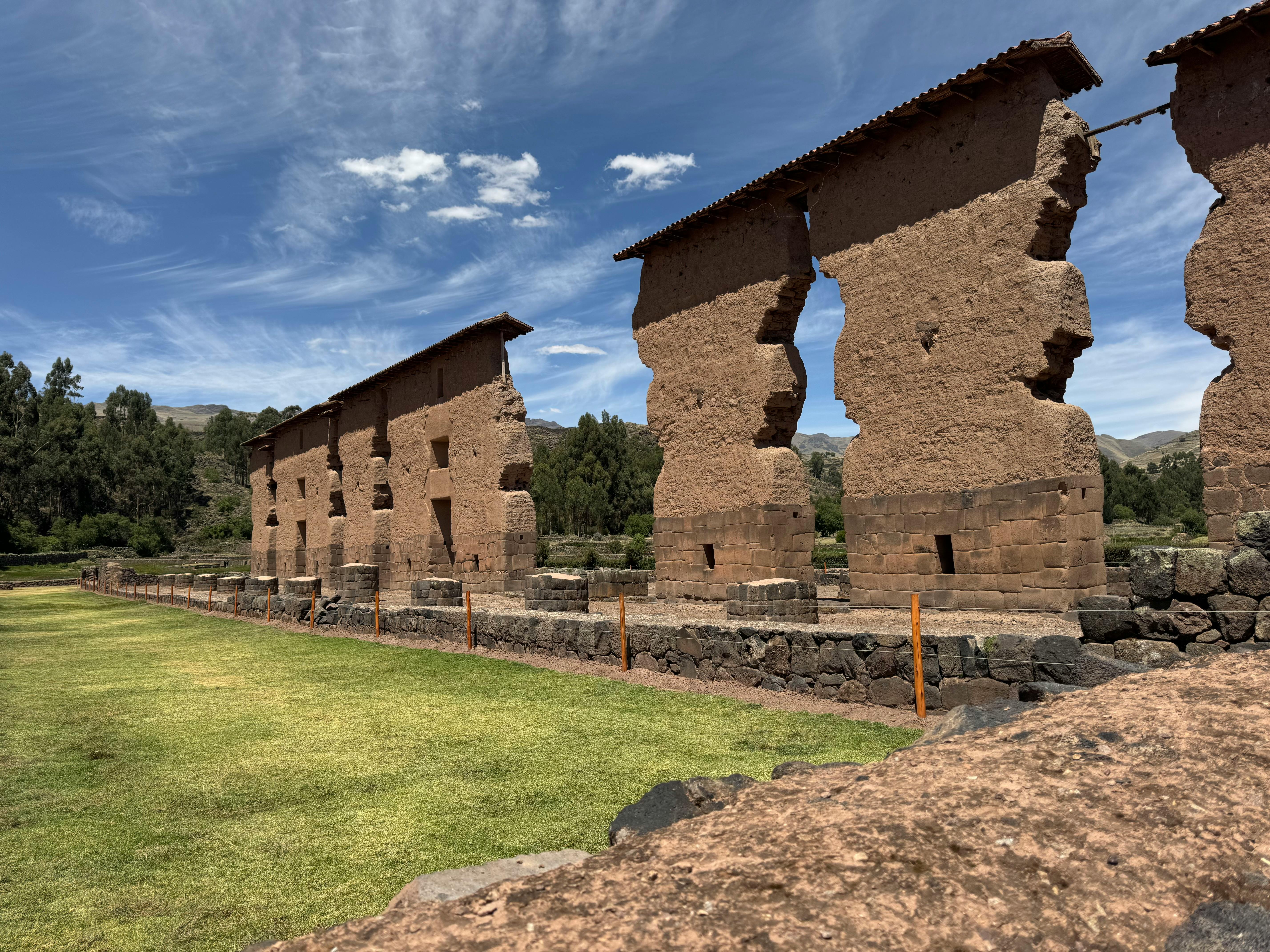 Raqch'i ruins showcasing ancient Inca architecture under a bright blue sky.