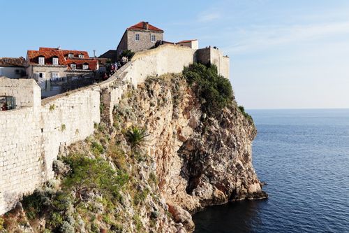 Free Scenic view of Dubrovnik's ancient fortress walls by the Adriatic Sea on a sunny day. Stock Photo