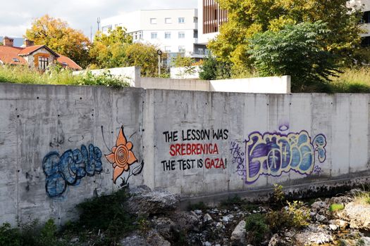 Graffiti art on a concrete wall in Mostar, Bosnia, displaying historical and cultural messages.