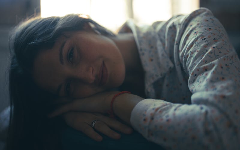 Gentle woman resting with soft lighting in bedroom