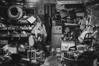 A thoughtful mechanic amidst a cluttered auto workshop in Nanjing, China.