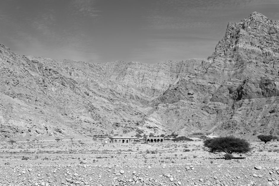 Dramatic black and white photo of a rocky mountain landscape with ancient ruins.
