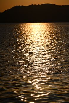 Beautiful golden sunset reflecting on a calm lake surface, evoking a serene and peaceful mood.