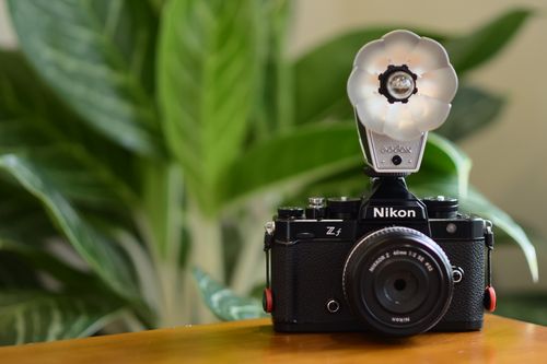 Free A classic Nikon camera with a unique flash attachment, perfect for photography enthusiasts. Stock Photo