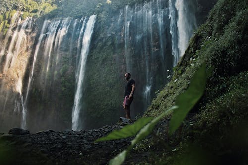 Photo Of Man Standing Near Falls