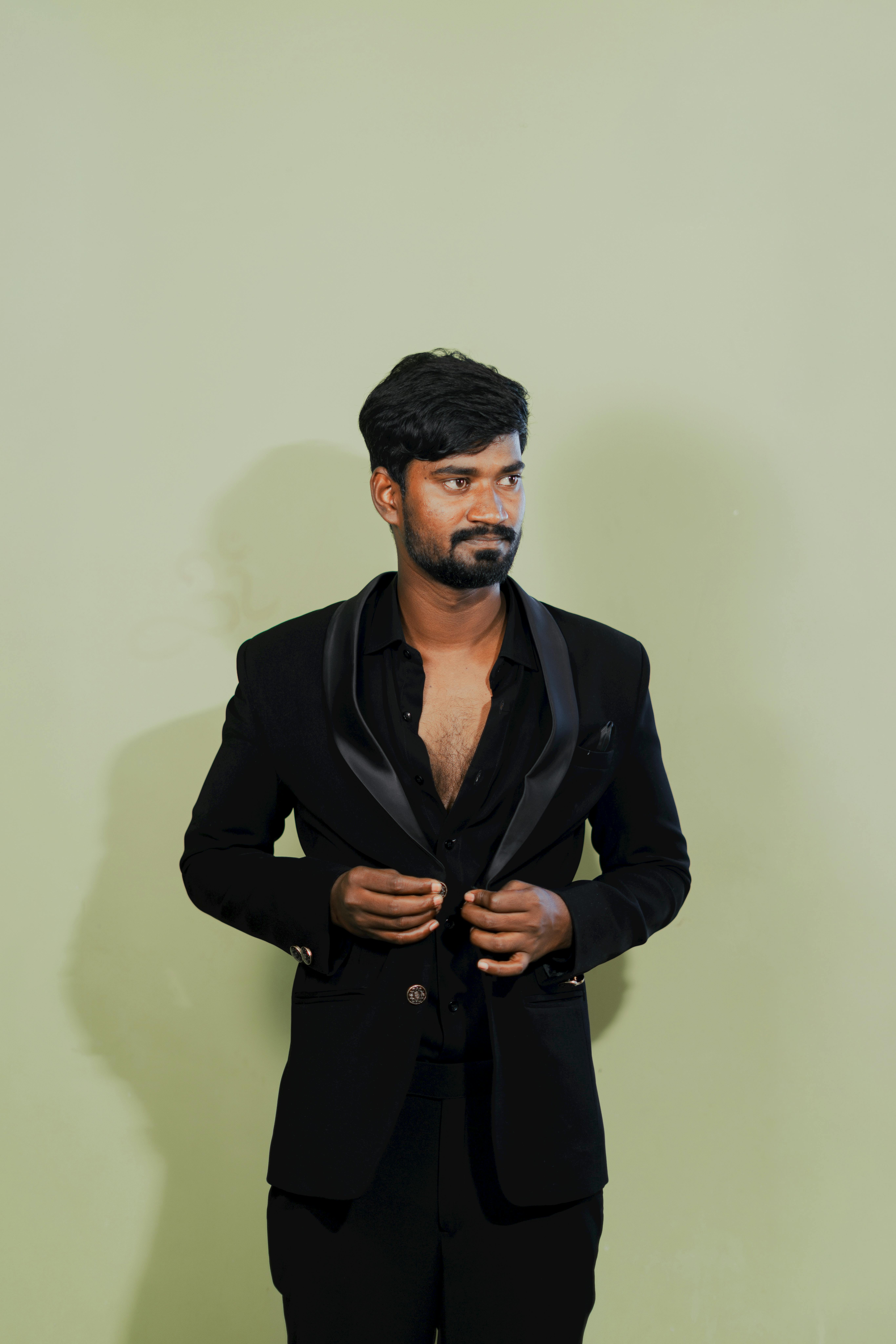 Stylish man in a black suit with a relaxed pose, perfect for fashion editorials.