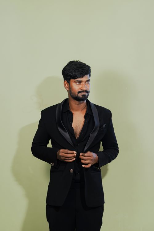 Free Stylish man in a black suit with a relaxed pose, perfect for fashion editorials. Stock Photo