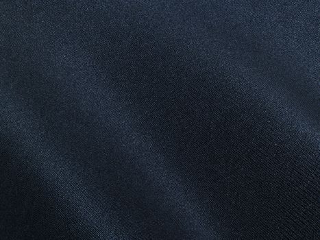Detailed closeup of dark blue denim fabric showcasing smooth texture and subtle folds.