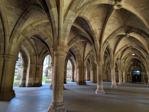 Free Stunning vaulted stone arches in a historic Gothic-style corridor with natural light. Stock Photo