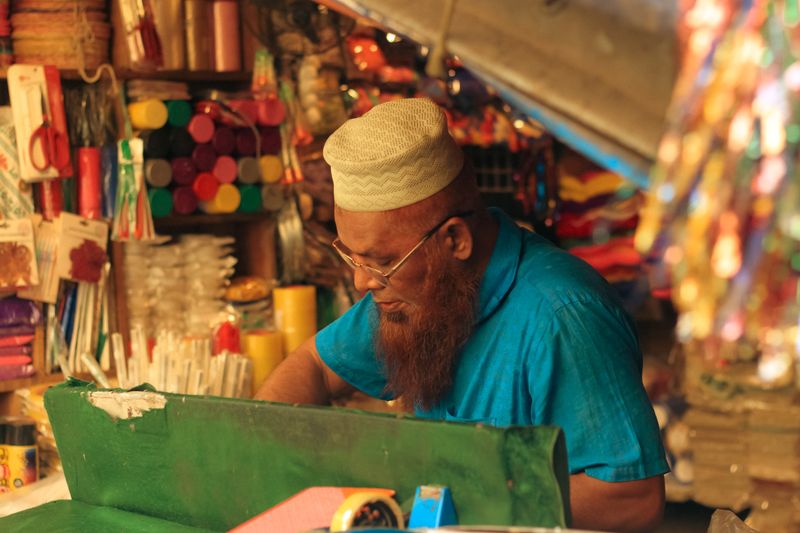A vendor working at a colorful market stall — photo by Tanha Tamanna Syed on Pexels