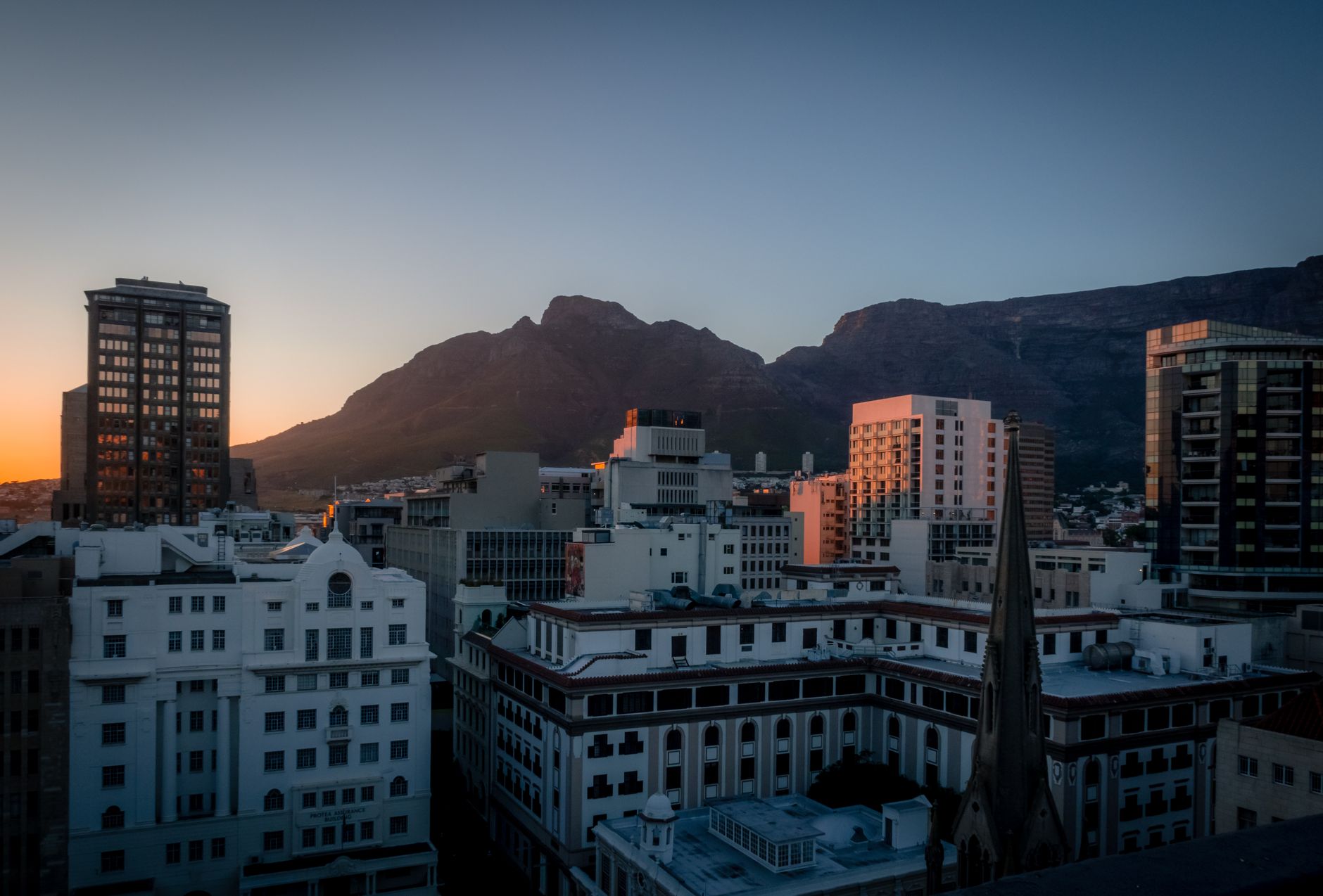 Cape Town racecourse at sunrise, thoroughbreds entering the paddock, crisp winter atmosphere