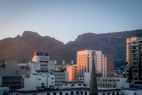 Free A view of Cape Town cityscape with Table Mountain in the background during sunset. Stock Photo