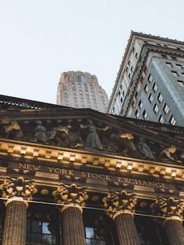 New York Stock Exchange facade with skyscrapers, captured at dusk.