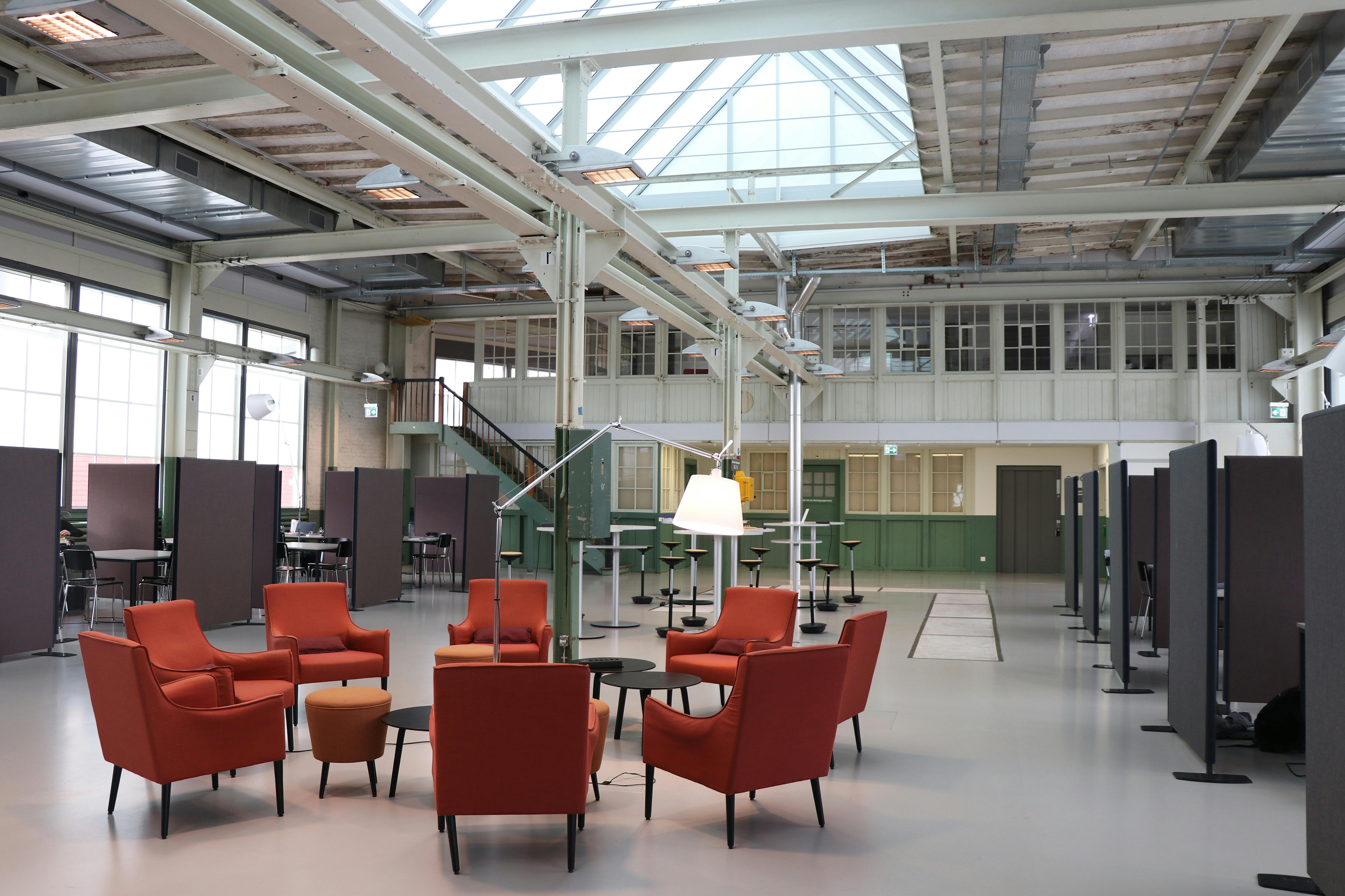 Spacious modern industrial workspace with red chairs in Winterthur, Zurich.