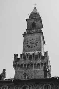 Black and white image of the historic clock tower in Vigevano, Lombardia, showcasing Italian architecture.
