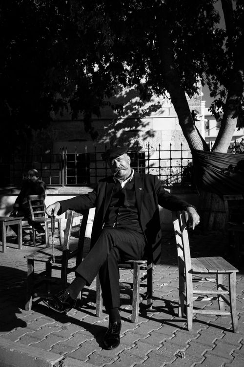 Free Sophisticated elderly man seated outdoors in classic black and white photography. Stock Photo