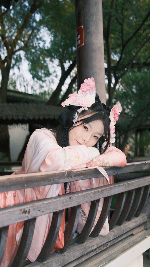Free Asian woman in traditional pink attire posing in a serene garden setting. Stock Photo