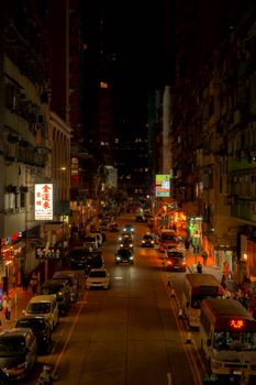 Vibrant street scene in Kowloon, Hong Kong, showcasing colorful lights and busy nightlife.