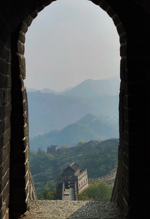 Free Scenic view of the Great Wall of China framed by a stone archway, capturing the vast landscape. Stock Photo