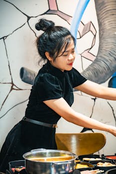 Young woman preparing a meal in a Vietnamese restaurant with artistic decor.
