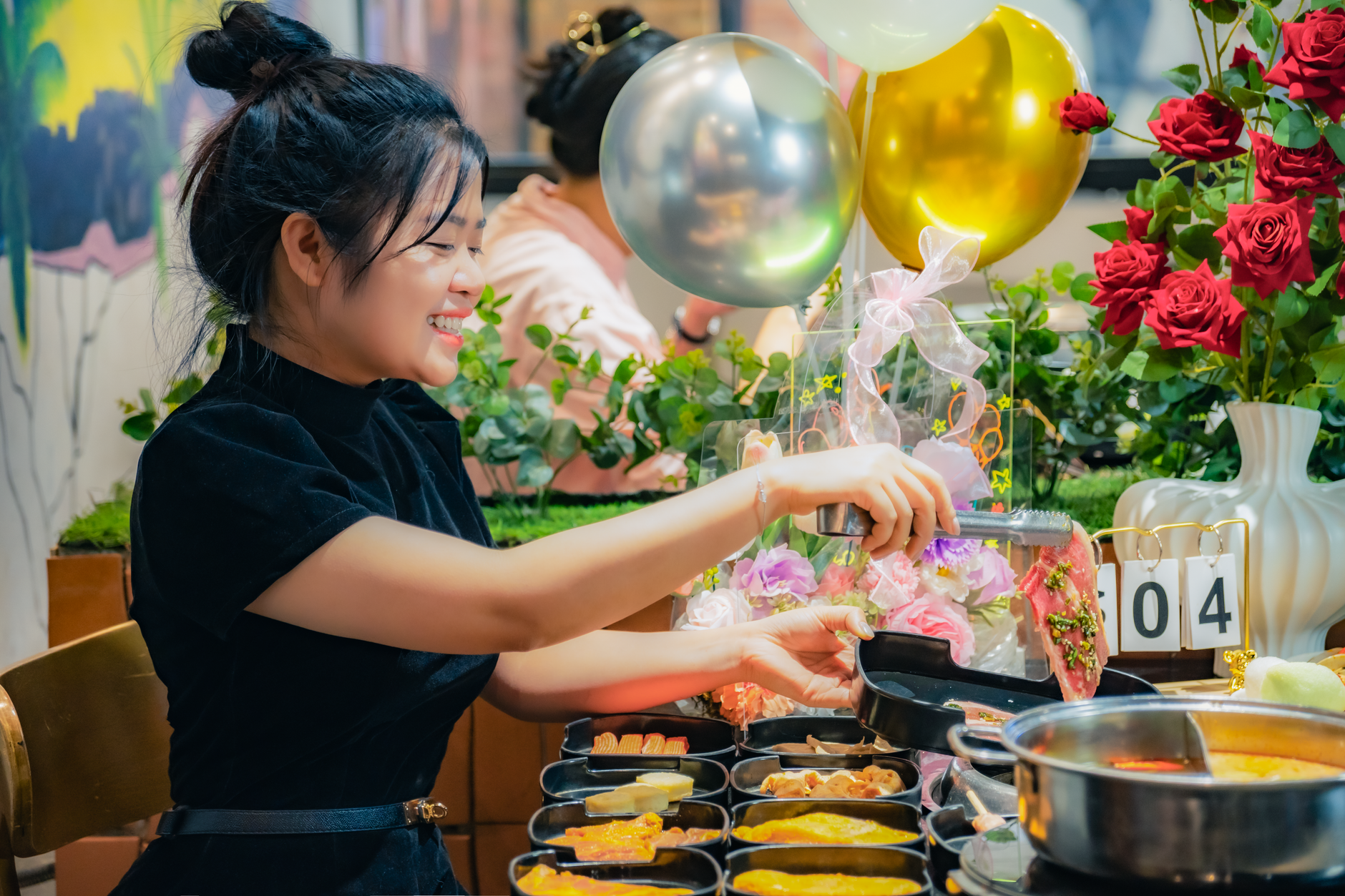 Young woman enjoying a meal celebration in a vibrant Vietnamese restaurant setting with festive decorations.