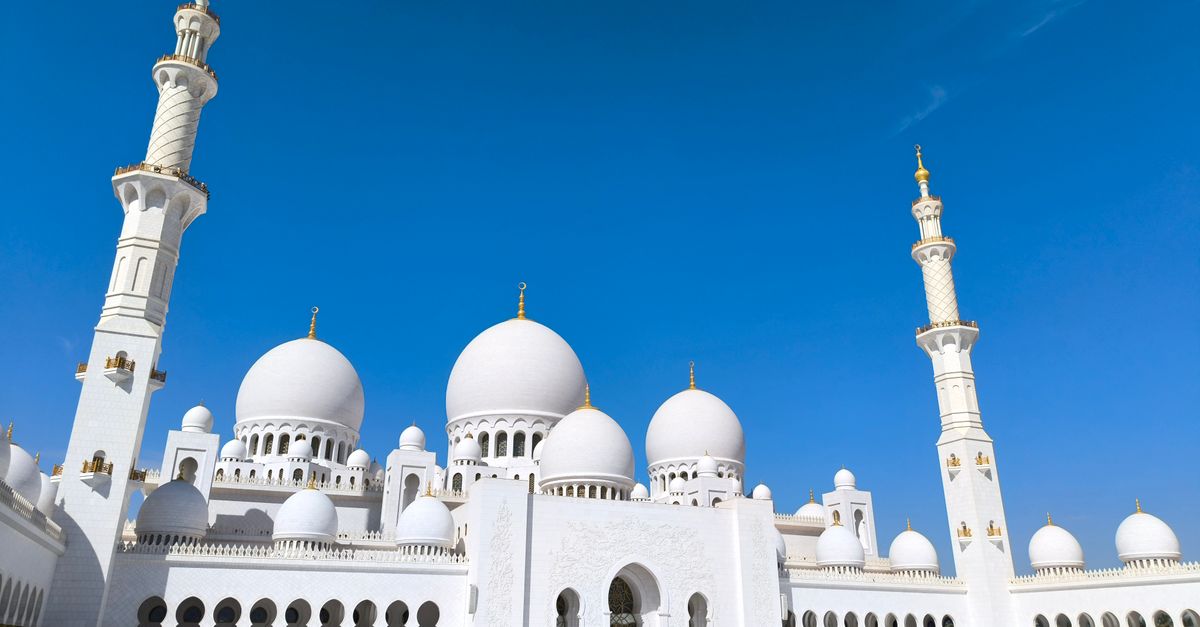 A stunning architectural capture of Sheikh Zayed Grand Mosque under a clear blue sky in Abu Dhabi.