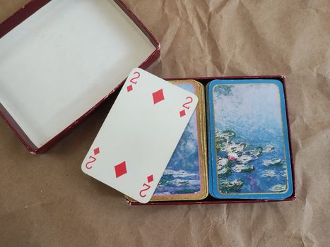 Close-up of vintage playing cards featuring art design on a rustic paper backdrop.
