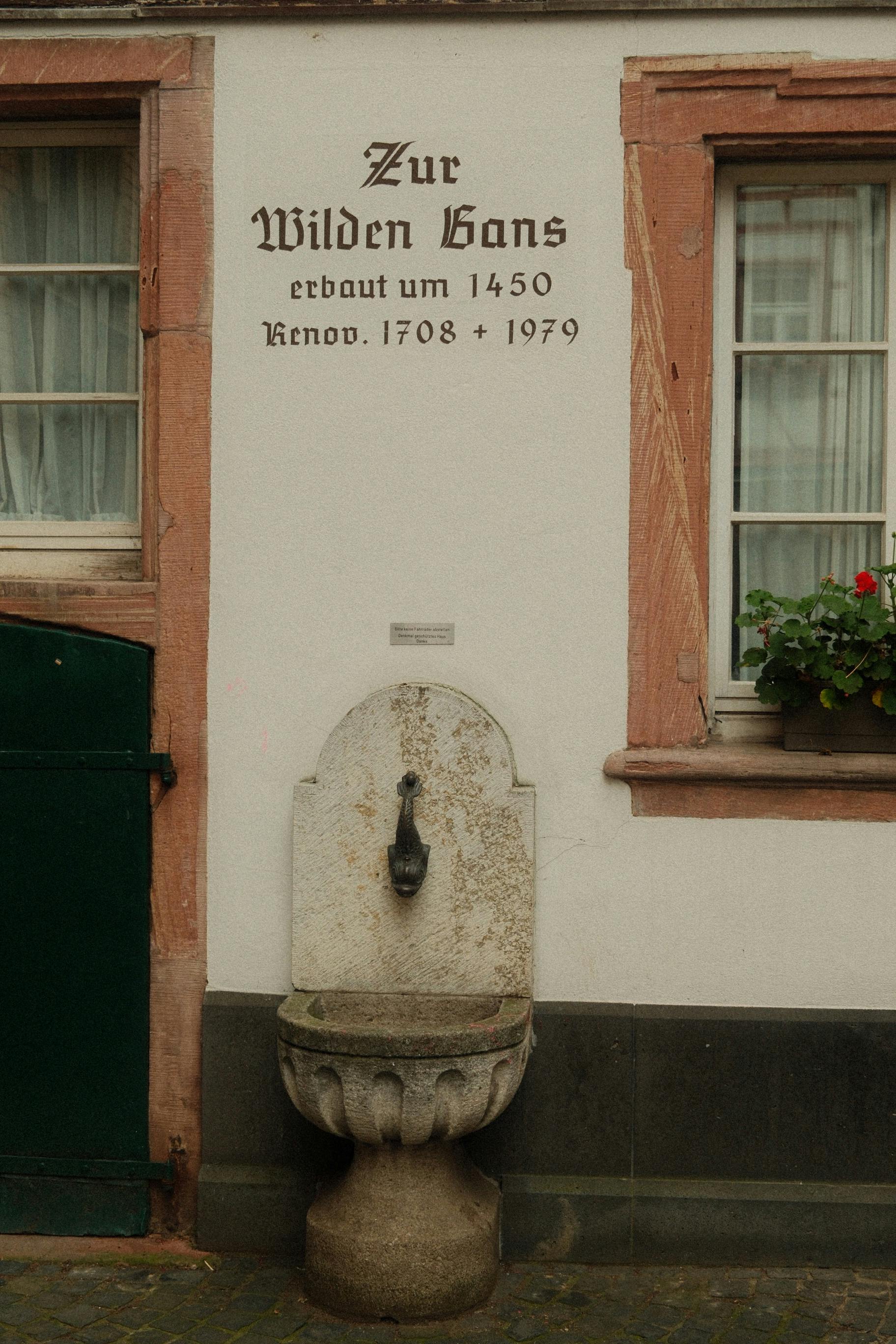 Stone fountain on an ancient half-timbered house facade in Mainz, Germany.