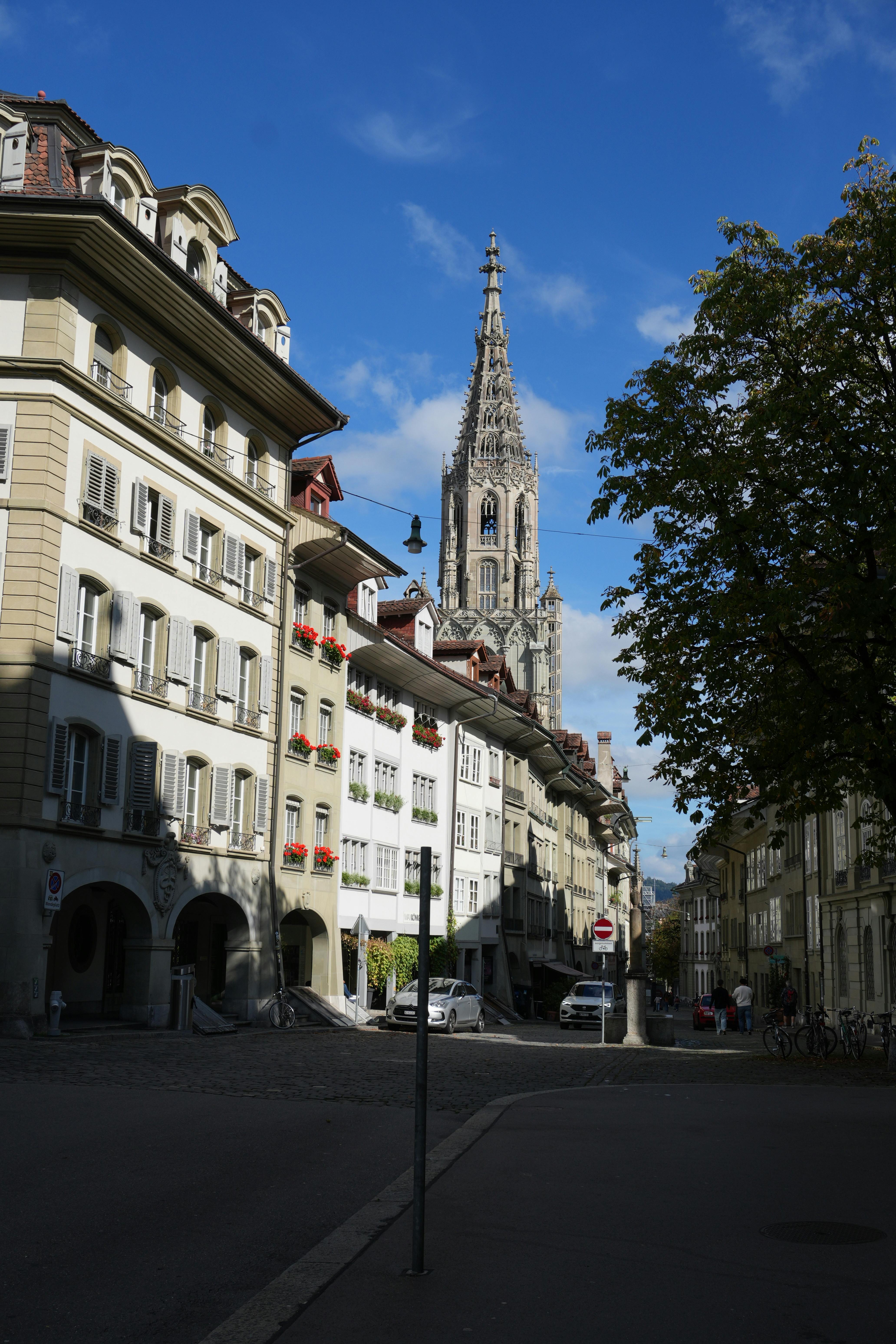 Charming street view of Bern with the iconic Bern Cathedral under clear autumn skies.