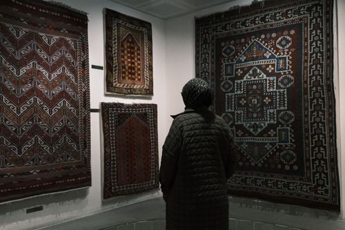 Free A woman admires traditional Turkish kilims at a museum in Bergama, İzmir. Stock Photo