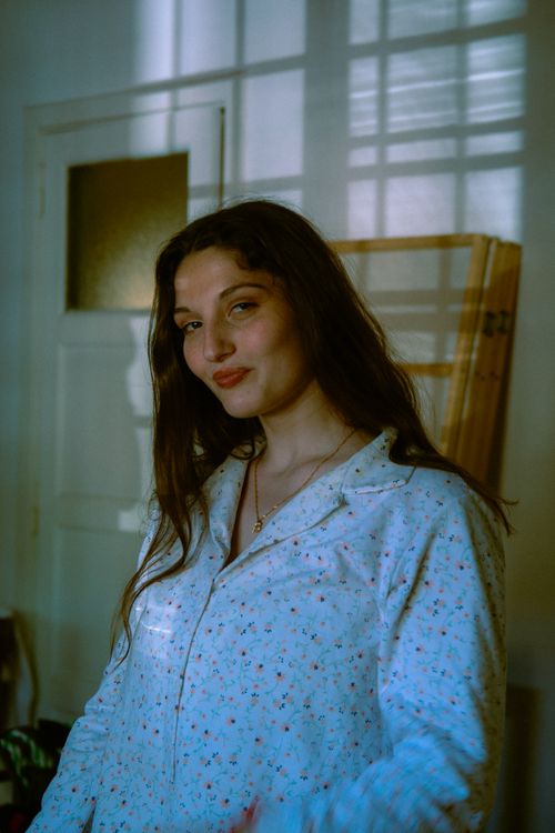 Free A young woman in a floral shirt poses indoors, exuding confidence and charm. Stock Photo