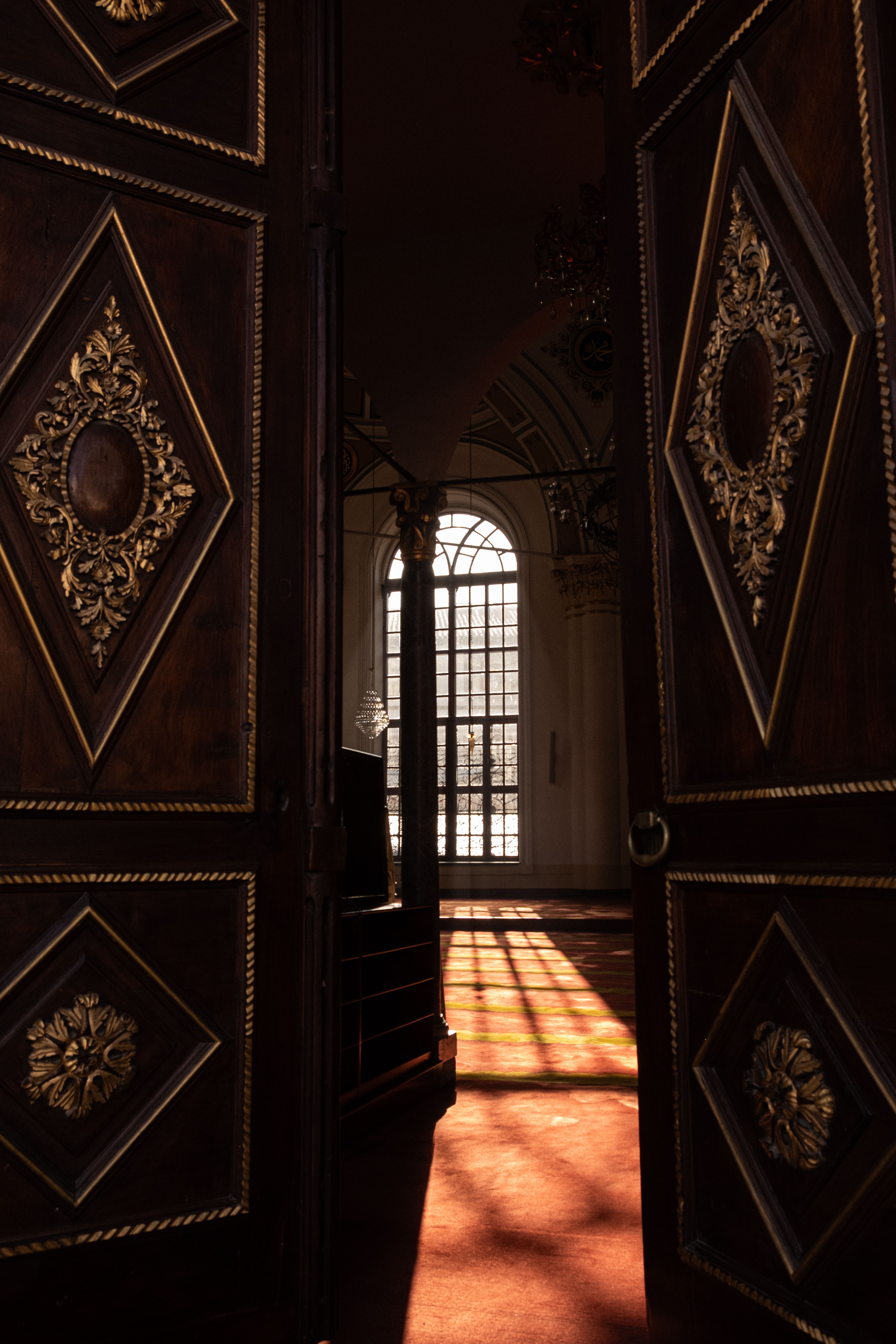 Elegant Interior with Ornate Wooden Doors Opening · Free Stock Photo
