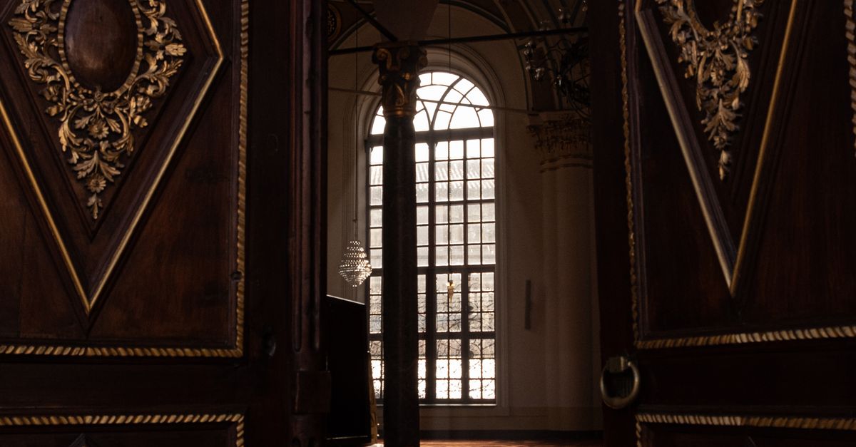 Elegant Interior with Ornate Wooden Doors Opening · Free Stock Photo