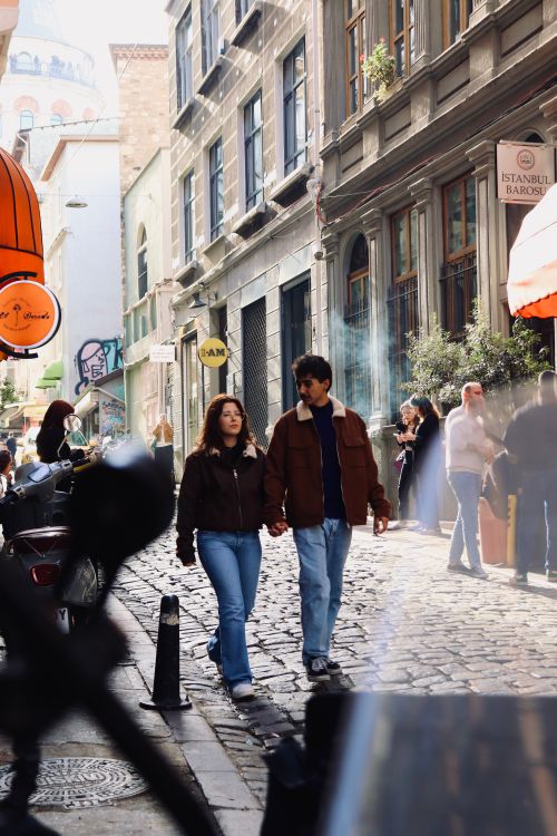 Free Romantic couple walking on a sunny cobblestone street in Istanbul. Stock Photo