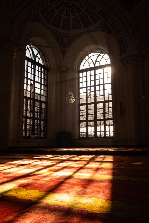 Free Sunlight streaming through cathedral windows casting warm shadows on the floor. Stock Photo