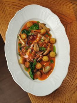 Delicious grilled chicken with vegetables and gravy on a white plate.
