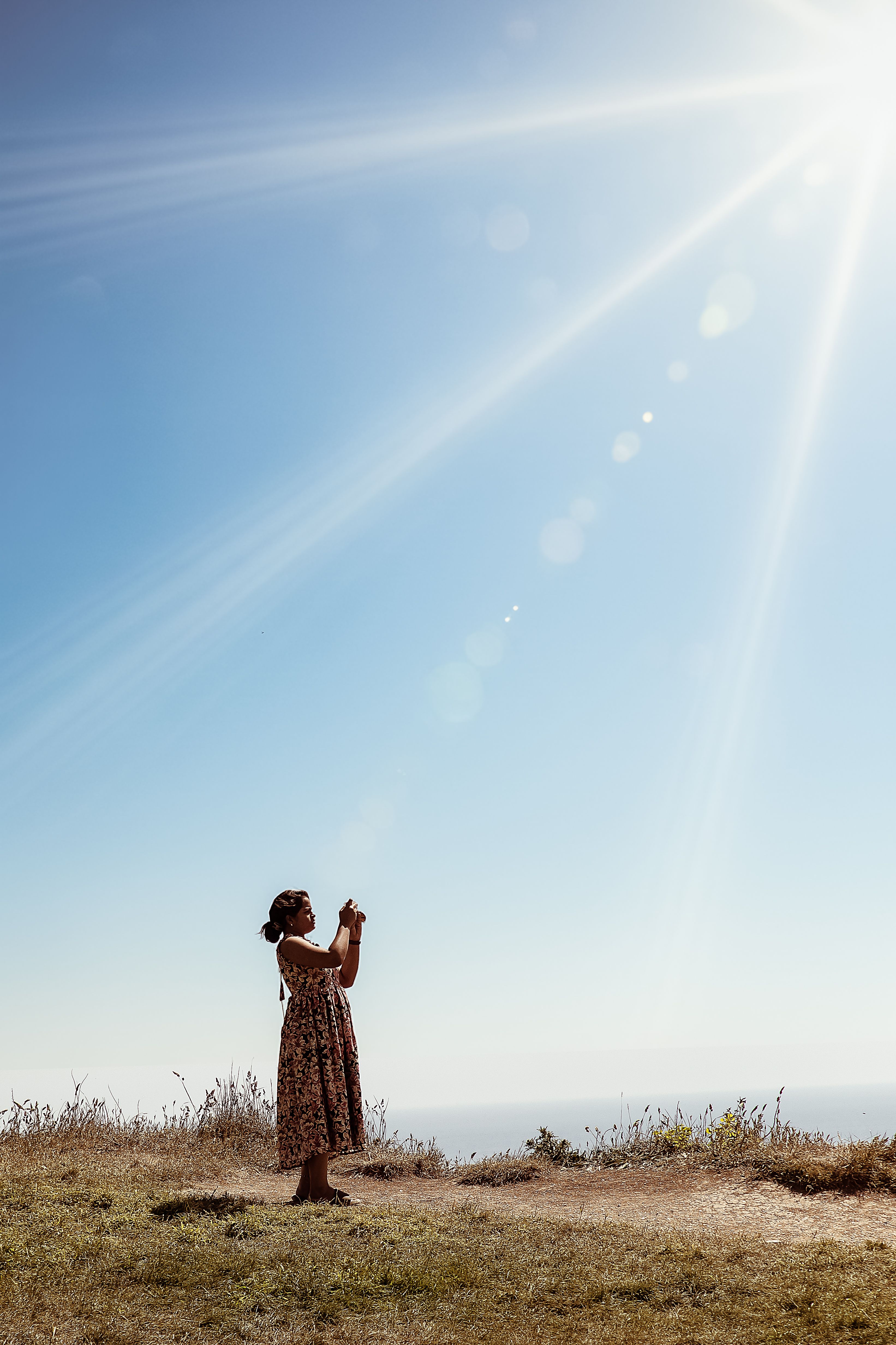 Woman Capturing Sunlight in Scenic Outdoor Setting · Free Stock Photo