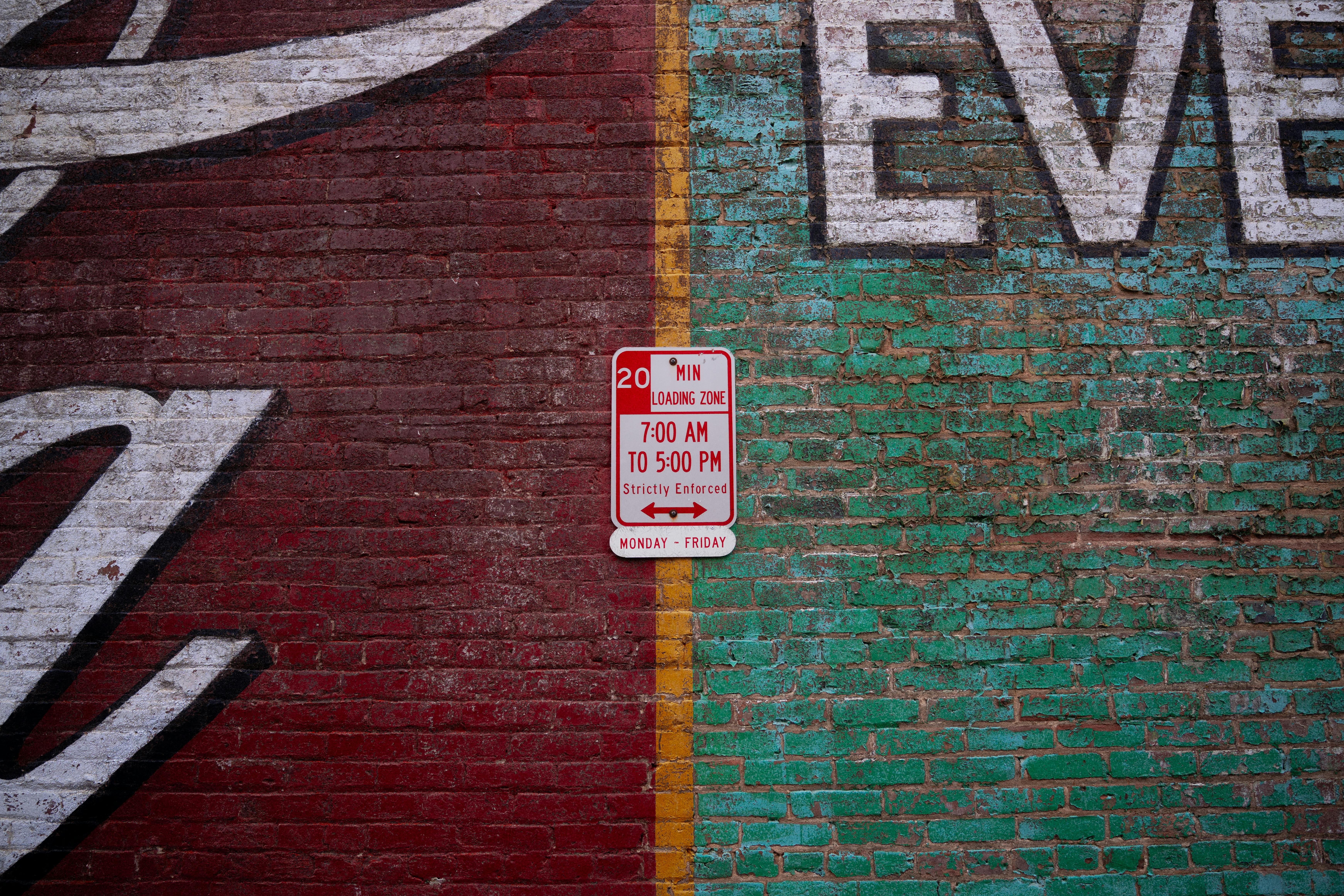 Free A vibrant mural on a brick wall featuring a loading zone sign. Perfect for urban themes. Stock Photo